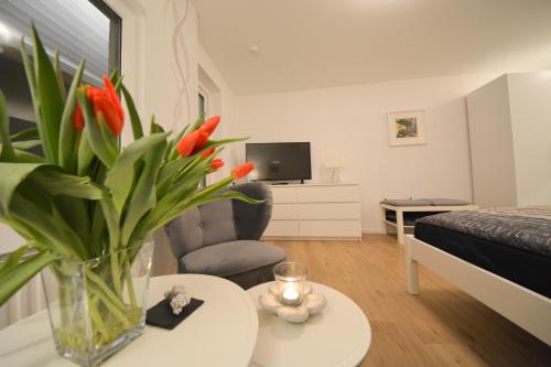 ベルンカステル・クースにあるFerienwohnung Moselのリビングルーム(テーブル上に花瓶付)