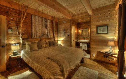 A bed or beds in a room at Les Bouleaux - Les Chalets Spa Canada