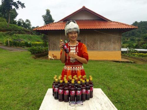a young girl standing next to a bunch of bottles of soda at Mong Homestay Resort in Pang Ung