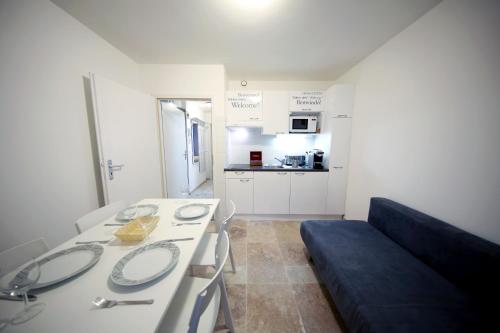 een kleine witte kamer met een bank en een keuken bij Cozy Studio (102) close to Cornavin Train Station in Genève
