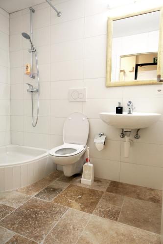 a bathroom with a toilet and a sink and a bath tub at Cozy Studio (102) close to Cornavin Train Station in Geneva