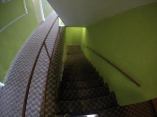 a staircase in a building with a green wall and stairsearch at Hotel Villa del Mar in Panama City