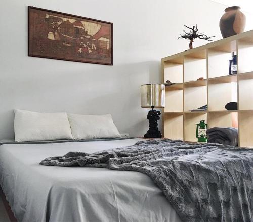 ein Schlafzimmer mit einem Bett mit einer grauen Decke darauf in der Unterkunft My Place Apt#1 in Praia