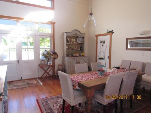 a dining room with a wooden table and chairs at Woolshed Bed & Breakfast in Takaka