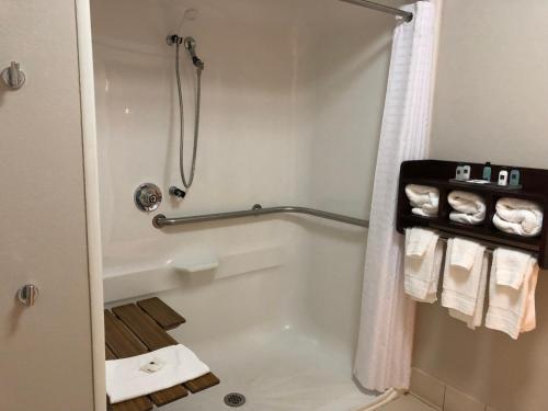 a bathroom with a tub and a shower with towels at Country Inn & Suites by Radisson, Cookeville, TN in Cookeville