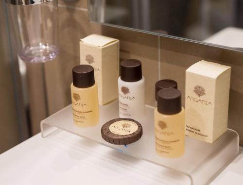 a shelf with three bottles of soap and a cupcake at 7th Floor Suite in Naples