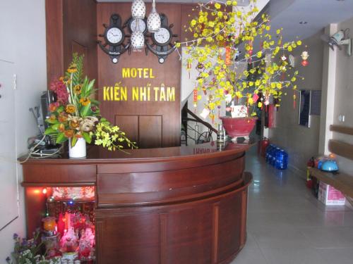 a lobby with a counter with flowers and clocks at Kien Nhi Tam Motel in Vung Tau