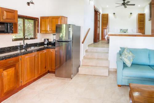 a kitchen with a stainless steel refrigerator and a blue couch at Hotel Villas Nicolas - Adults Only in Manuel Antonio