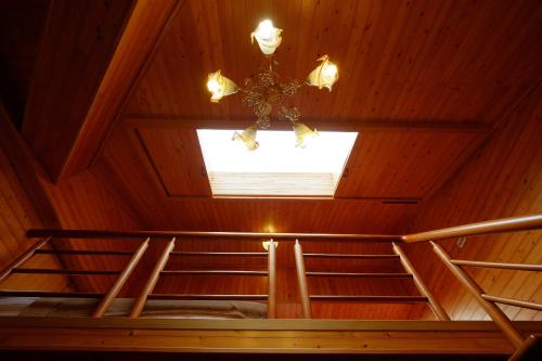 a room with a ceiling with a window and a chandelier at Mandy's House B&B in Shangwu