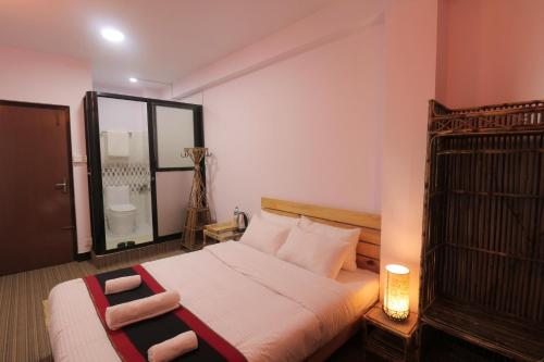 a bedroom with a large bed and a bathroom at Easy Homes - Ashok Stupa in Pātan