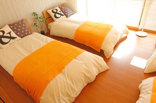 two beds in a room with wood floors at Chidori Inn Fukuromachi Hiroshima in Hiroshima