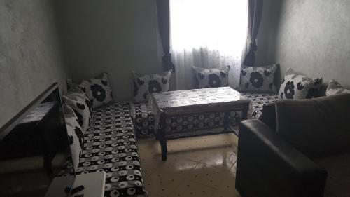 a room with a couch and a table and a window at Addoha Apartment in Tangier