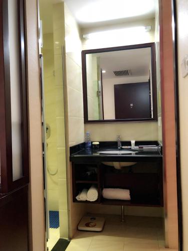a bathroom with a sink and a mirror at Xijiao Hotel Beijing in Beijing