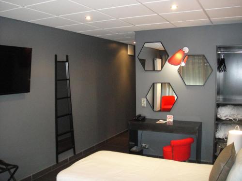 a room with a bed and a desk and a mirror at Hôtel du Casino de Capvern in Capvern