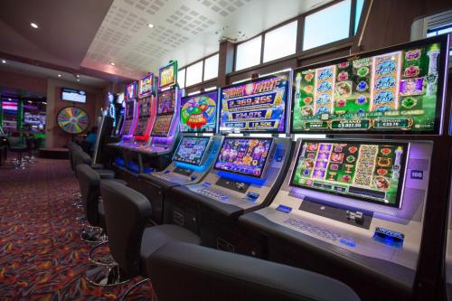a row of slot machines in a casino at Hôtel du Casino de Capvern in Capvern