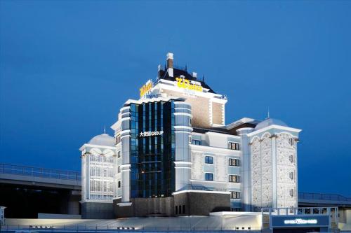 un edificio blanco alto con un letrero amarillo. en Hotel Waltz Chiryu (Adult Only) en Chiryu