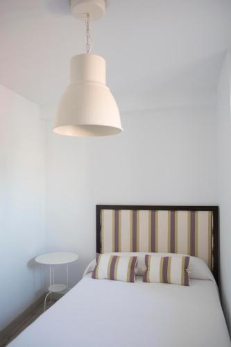 1 dormitorio con 1 cama con lámpara y mesa en VIVIENDA DE USO TURÍSTICO CASA ABAD, en Ávila