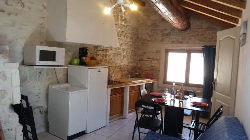une petite cuisine avec une table et un micro-ondes dans l'établissement Luclem, à Arles