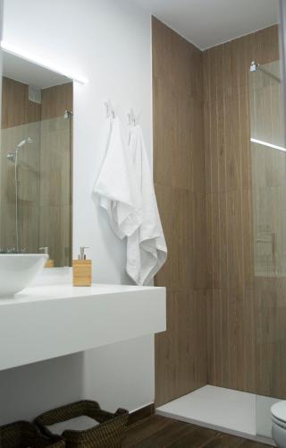 a bathroom with a sink and a shower with a mirror at VIVIENDA DE USO TURÍSTICO CASA ABAD in Ávila