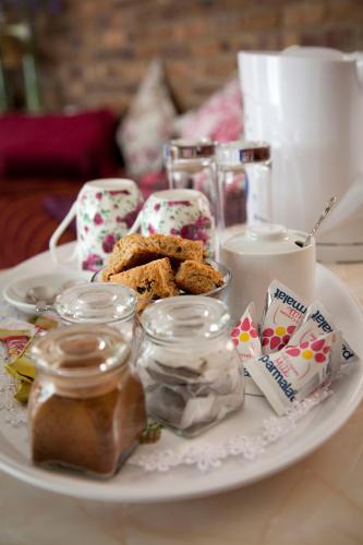 a white plate with cookies and jars on a table at La Bella B&B Under The Fig Tree in Bela-Bela
