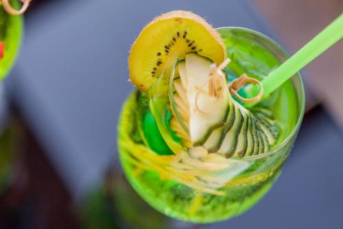 a drink with a kiwi and a slice of fruit at Hotel Sa Cheya Relais & Spa in Alghero