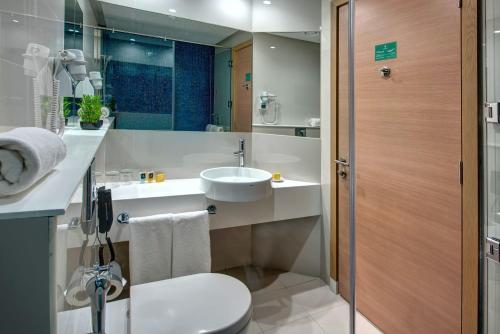 La salle de bains est pourvue d'un lavabo, de toilettes et d'une douche. dans l'établissement Al Khoory Inn Bur Dubai, à Dubaï