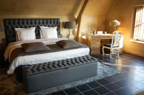 a bedroom with a bed and a desk and a chair at Boutique Hotel De Brakelhoen in Brakel