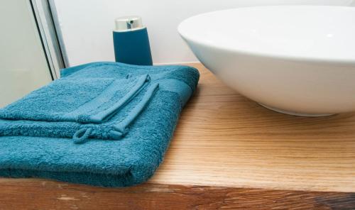 un asciugamano blu seduto su un pavimento in legno accanto a una ciotola di LaGrange-Chambres d'hôtes a Liegi
