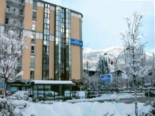 duży budynek z śniegiem przed nim w obiekcie Hotel Norden Palace w Aoście