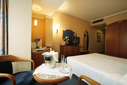 una camera d'albergo con letto e tavolo con macchinetta del caffè di Hotel Norden Palace ad Aosta