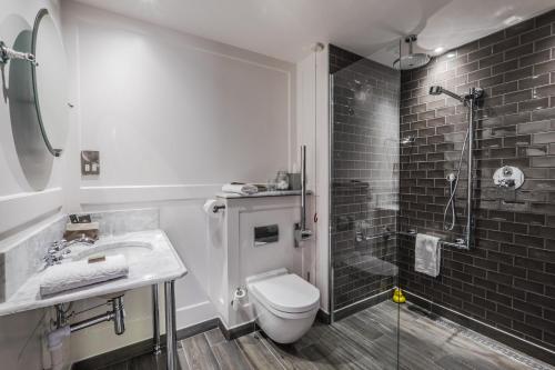 a bathroom with a toilet a sink and a bathtub at Coach & Horses Hotel in London