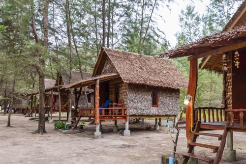 un grupo de cabañas de madera en el bosque en Rakkan Resort en Ko Phra Thong