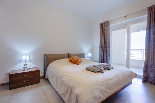 a bedroom with a bed and a dresser and a window at Seafront Apartment Sliema in Sliema