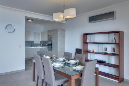 a dining room and kitchen with a table and chairs at Seafront Apartment Sliema in Sliema