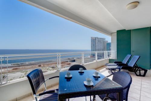 a balcony with a table and chairs and a view of the ocean at Seafront Apartment Sliema in Sliema