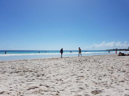 a group of people walking on the beach at Quetzal Apartment in Akumal