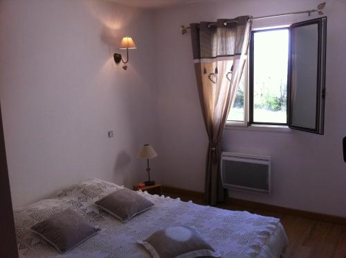 une chambre avec un lit et une fenêtre dans l'établissement Lou Mazet, à Saint-Privat-de-Champclos