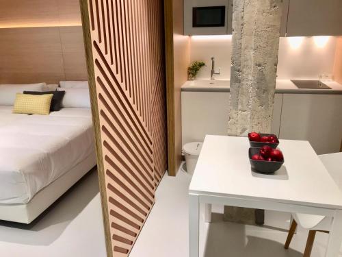 a bedroom with a bed and a table with apples on it at Inside Bilbao Apartments in Bilbao
