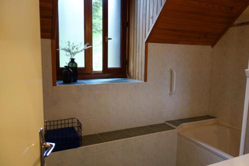 a bathroom with a tub and a window at Farmhouse with mountain view in Le Claux