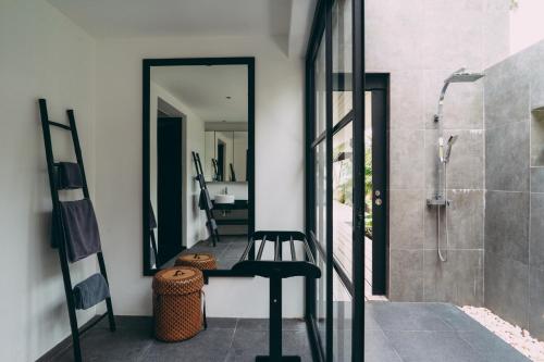 a bathroom with a walk in shower and a stool at Le Motu in Taling Ngam Beach