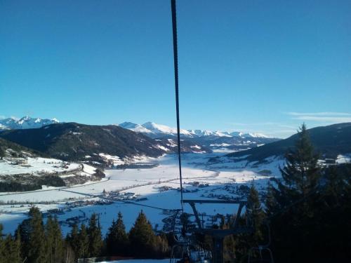 a gondola ride up the mountain with snow covered mountains at Ferienwohnung Holzer in Sankt Michael im Lungau