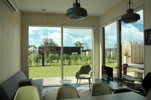una sala de estar con una gran ventana con vistas a un patio en Wadzand en Midsland