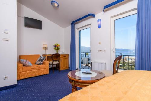 um quarto de hotel com um sofá e uma mesa e um quarto em Villa Mediterana em Seget Vranjica