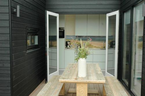 una cocina con una mesa con un jarrón de flores. en Wadzand en Midsland