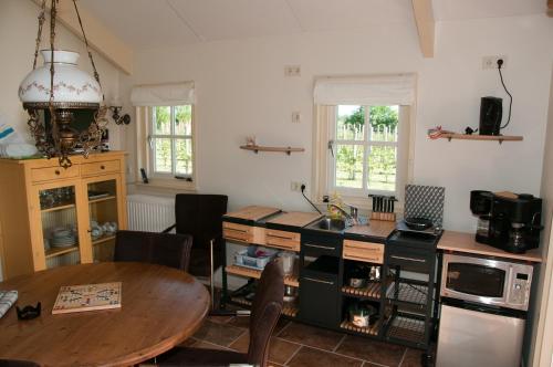 a kitchen with a wooden table and a table and a dining room at Park Nieuwgrapendaal in Terwolde