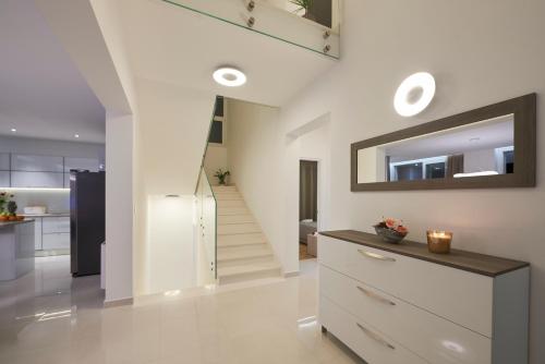 a living room with a staircase and a mirror at Villa Trogir in Trogir