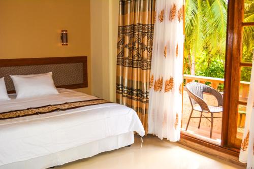 a bedroom with a bed and a sliding glass door at Remora Inn in Faafu