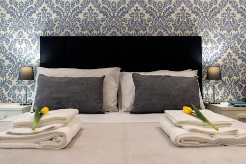 um quarto com uma cama com duas almofadas e duas toalhas em lungomare rooms em Castellammare di Stabia