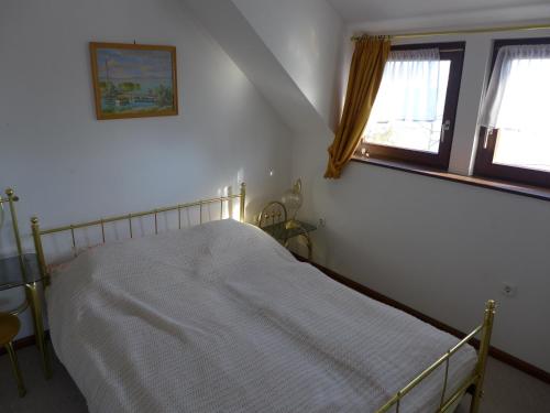 1 dormitorio con 1 cama en una habitación con ventana en Lakeside Apartment, en Tihany