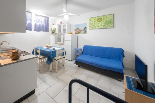 a living room with a blue couch and a table at Deliziosi Appartamenti Sul Mare in Leuca